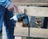 Bit-Grip Man pointing at drill hanging from Bit-Grip & screw on sawhorse